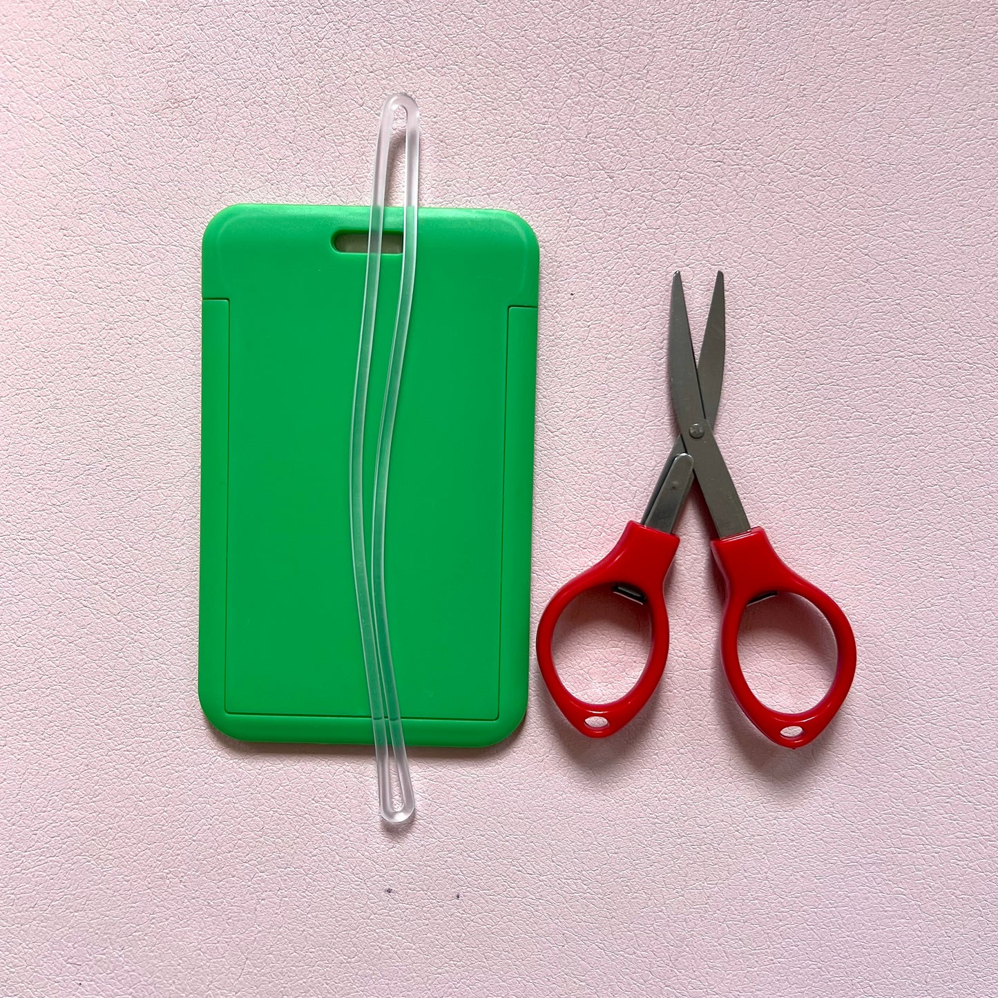 Green luggage tag with travel approved scissors and luggage tag attachments. 