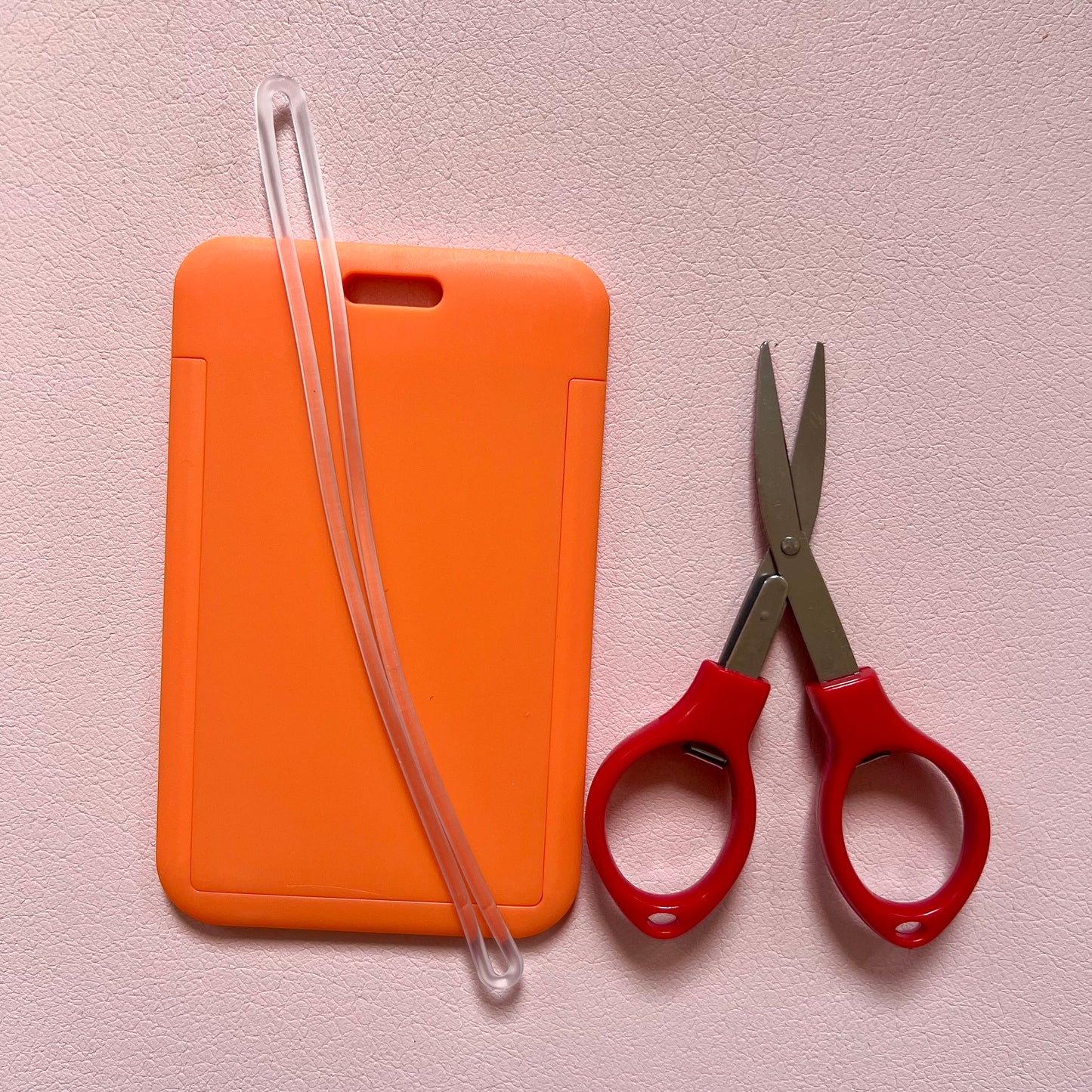 Orange luggage tag with travel approved scissors and luggage tag attachment