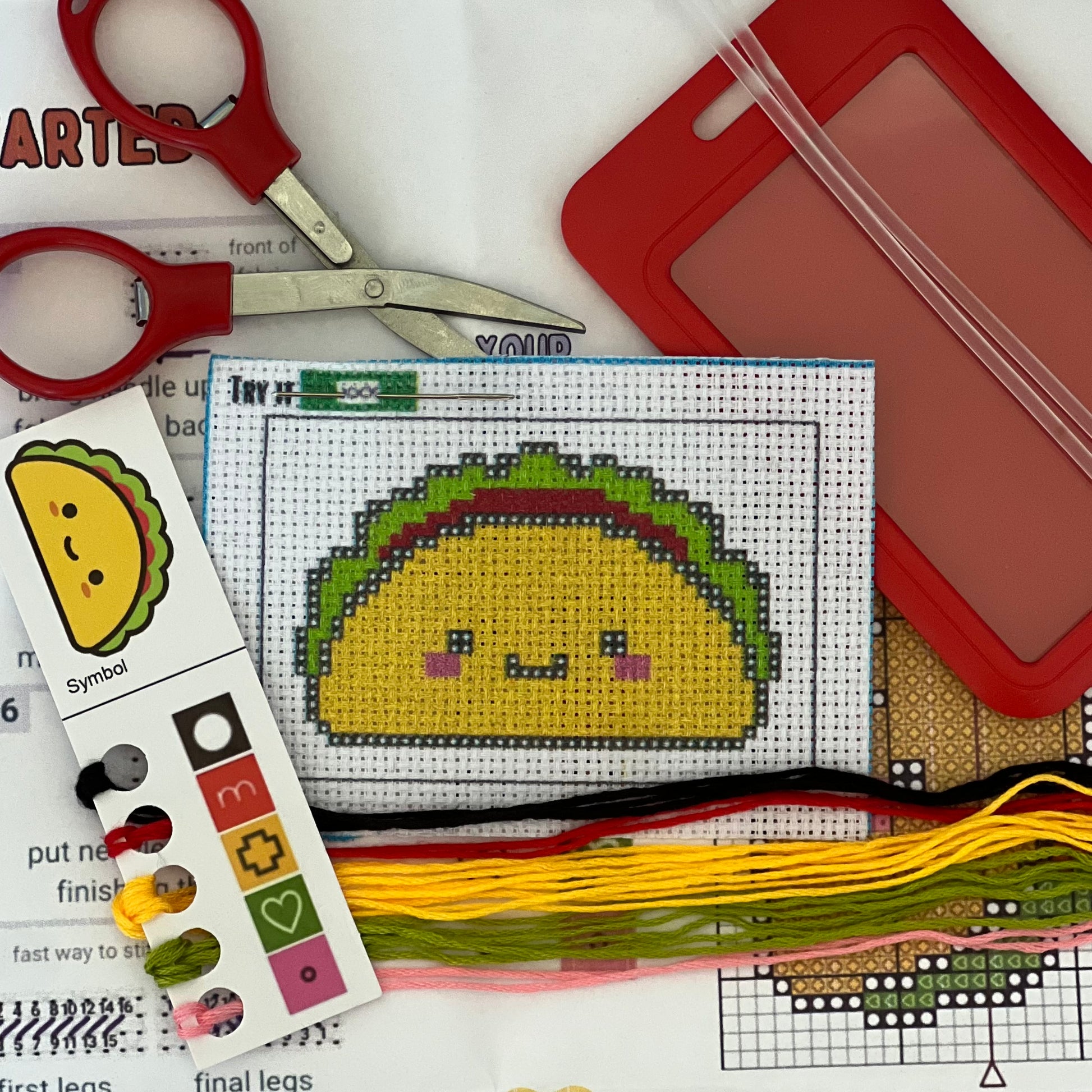 Timmy the Taco mini stamped cross stitch DIY luggage tag kit with a red bag tag, luggage tag attachment, Scissors, needle and thread, stamped Aida fabric, color instructions